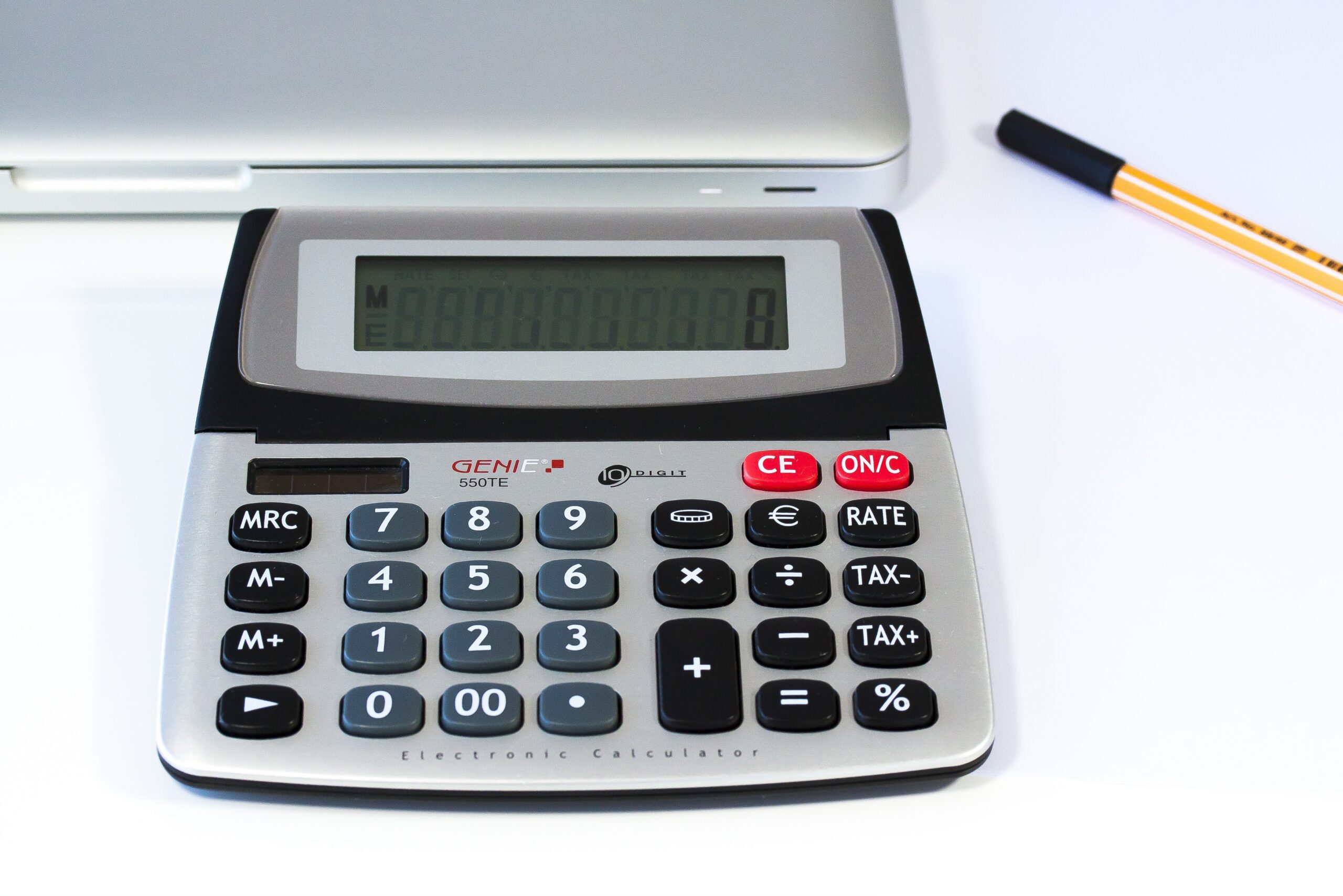 Persona utilizando una calculadora y una computadora para revisar sus finanzas