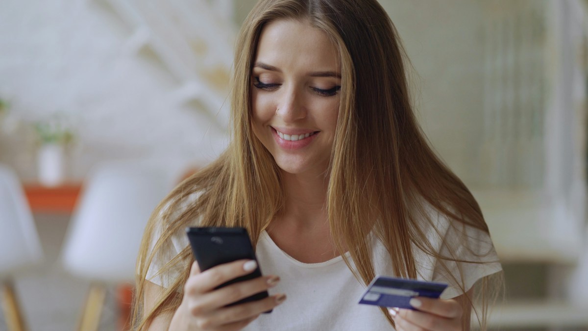 Tarjeta de crédito y celular para consultar beneficios y servicios