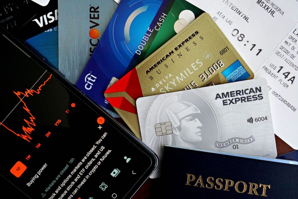 Persona utilizando una tarjeta de crédito y revisando información financiera en su celular